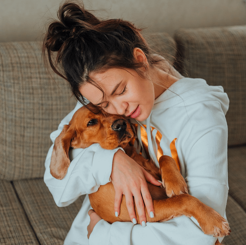 A woman hugging a dog for dog training and socialization